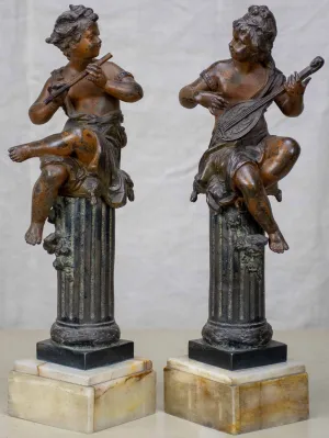Antique French statues of angels playing music