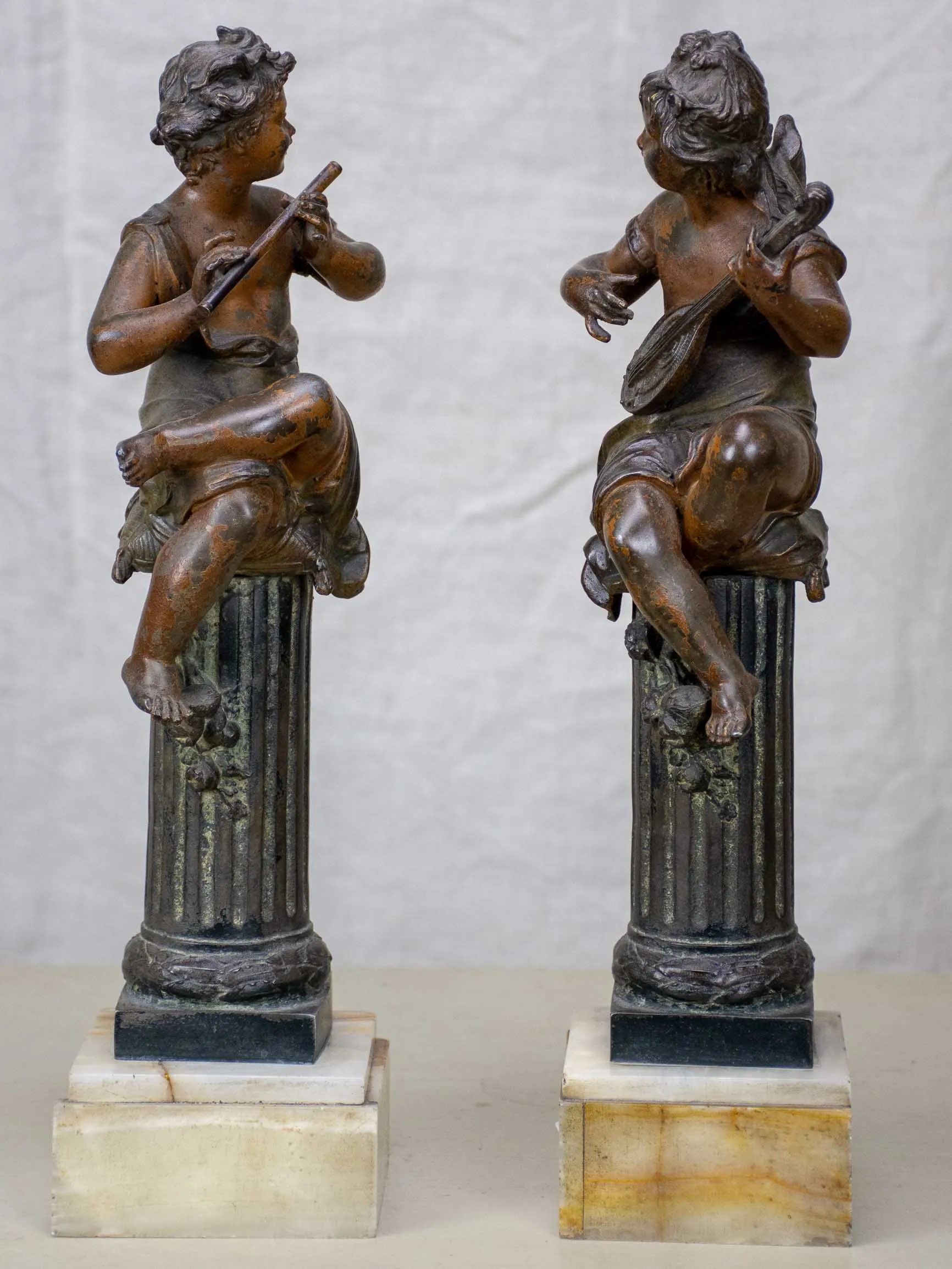 Antique French statues of angels playing music