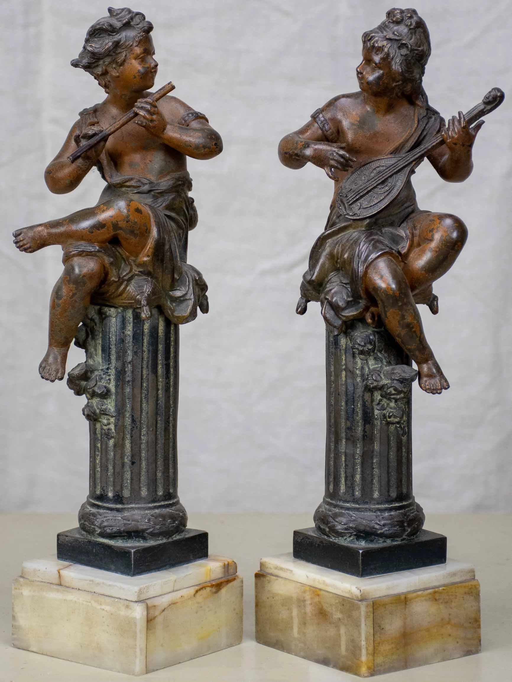 Antique French statues of angels playing music